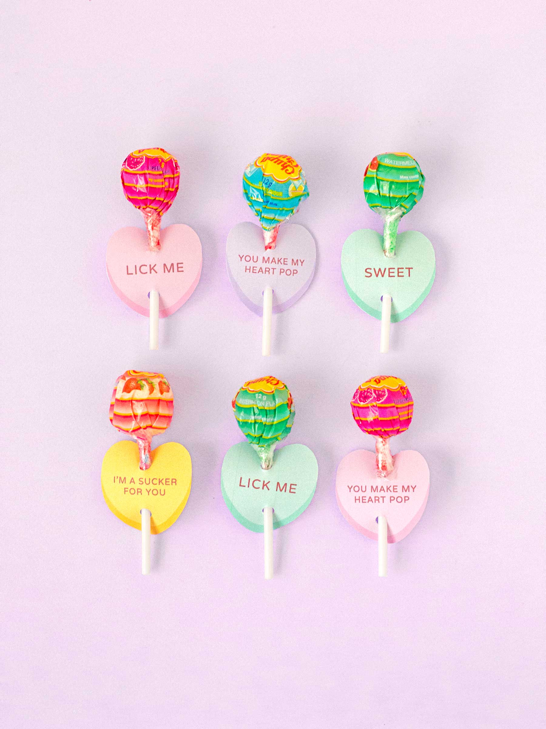 Light purple background, 6 lollipops with conversation heart paper holders